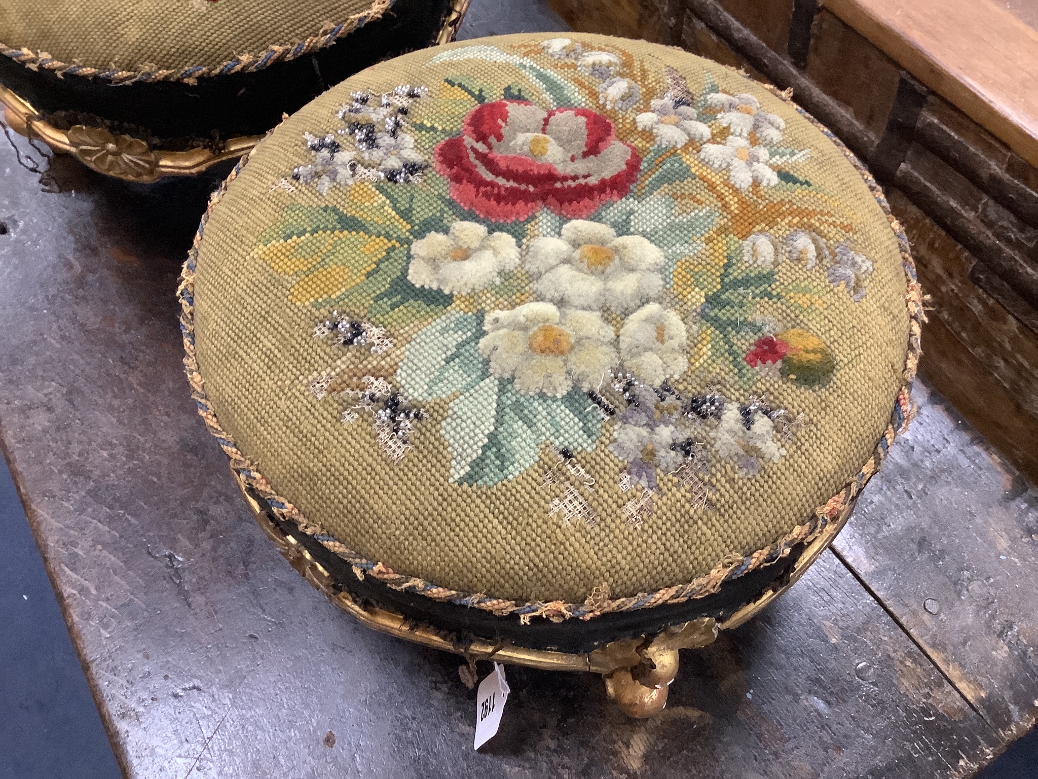 A pair of Victorian floral tapestry circular carved giltwood footstools, length 36cm, height 20cm